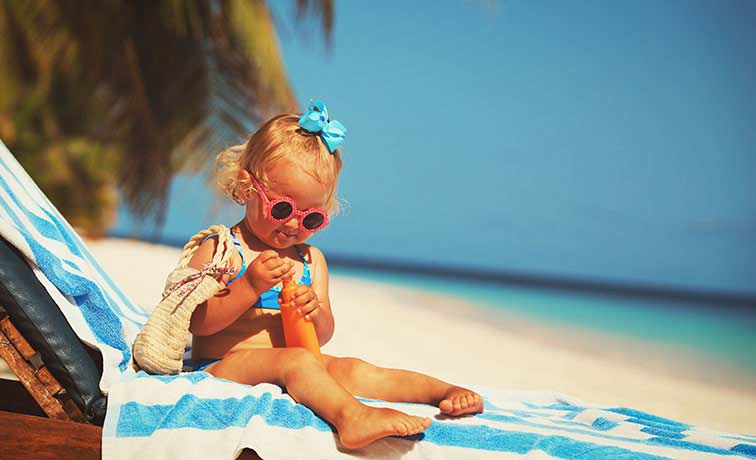 Bild: Kind wird mit Sonnencreme geschützt